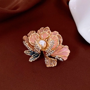 Détail de la broche fleur en émail rose plaquée or avec perle centrale et petits diamants
