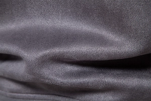 Gros plan sur le tissu en daim gris foncé montrant la texture fine et le fini mat