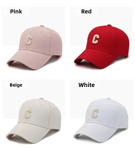 Detail view of baseball caps in pink, red, beige and white with C embroidery