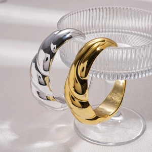 Twisted rope texture metal bangles in gold and silver finish on glass stand