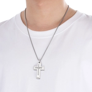 Close-up of a silver cross pendant necklace with a round box chain on a white t-shirt