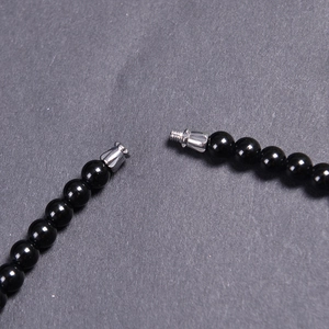 Macro shot of 6mm black agate beads necklace showing a detailed silver metal screw clasp