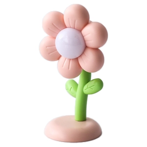 Cute cartoon flower night light with pink petals and green leaves on white background