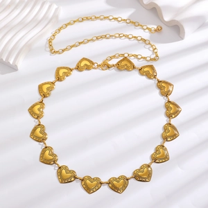 Detail view of heart-shaped gold metal waist chain with vintage dotted textures