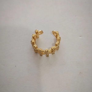 Detailed macro view of a vintage gold ear cuff featuring sparkling micro-pave zircons