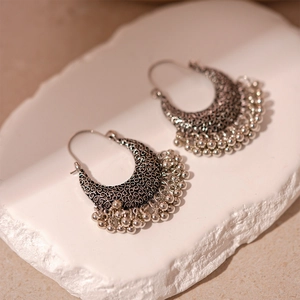 Détail macro de boucles d'oreilles ethniques en argent avec motifs et glands