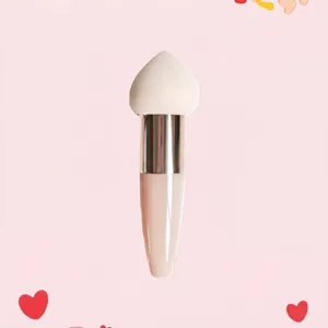 Close-up of heart-shaped sponge makeup brush with ergonomic pink handle and white tip