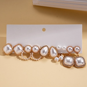 Detailed set of white pearl earrings with gold metal bases in geometric and teardrop shapes