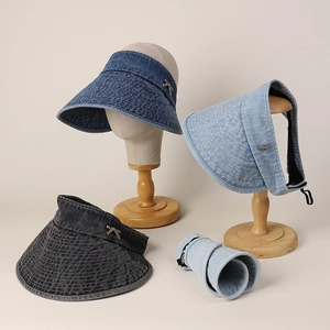 Detail of foldable denim sun visors showing washed texture and portable rolled design