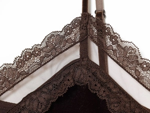 Dettaglio del corpetto in velluto marrone scuro con pizzo delicato e inserti in rete