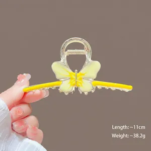 Detail of 11cm yellow butterfly claw clip showing metal spring and acrylic texture