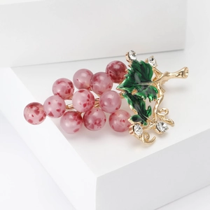Détails de la broche raisin avec perles roses, feuilles en émail vert et strass scintillants