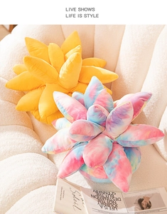 Detail of yellow and ombre blue plush succulent pillows on a soft white sofa