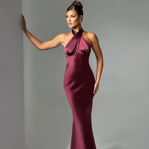 Detail of burgundy satin maxi dress featuring a crisscross halter neck and silky texture