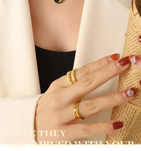 Detailed view of layered 18k gold-plated titanium steel rings with twisted and smooth texture