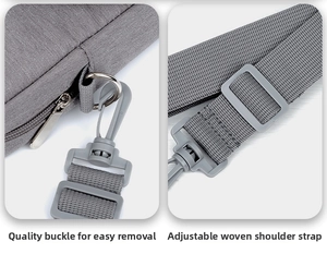 Detail of adjustable fabric shoulder strap and detachable buckle on grey laptop bag
