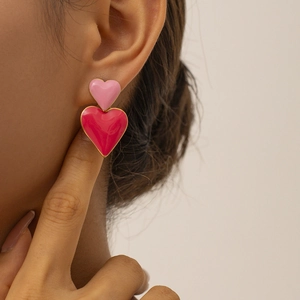 Eleganti orecchini a cuore in rosa e magenta indossati da una modella per lo stile