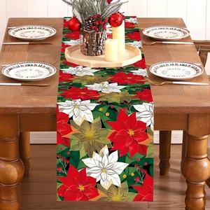 Floral Christmas table runner with red poinsettia pattern on a festive wooden dinner table