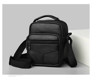 Macro shot of three-layer zipper compartments on black leather crossbody bag for men