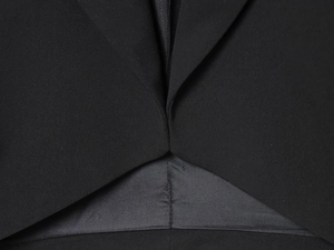 Detail shot of black blazer with premium fine twill texture and precision stitching