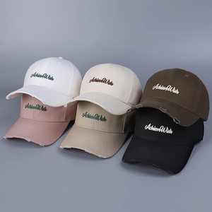 Detail of distressed cotton baseball caps with AchieveWish embroidery in multiple colors