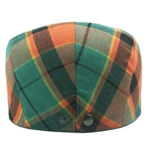 Detail of colorful plaid beret flat cap showing metal buckle and woven fabric texture