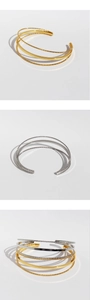 Macro detail of multi-layer geometric open cuff with twisted rope and smooth metal texture
