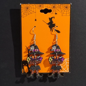 Detail of wooden Halloween earrings featuring witch hat and bat motifs on themed card
