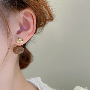 Vue détaillée de boucles d'oreilles ovales plaquées or avec perles en résine brune