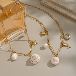 Collier en acier inoxydable doré avec des charmes marins étoile de mer et dauphin