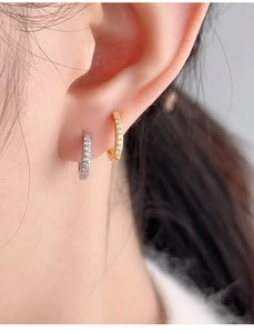 Detailed view of gold and silver S925 sterling silver pave cz hoop earrings on ear