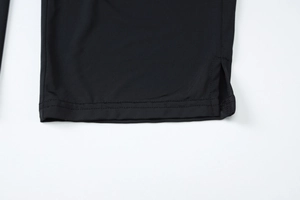 Détail d'une combinaison noire avec fente latérale et ourlet à double couture soignée