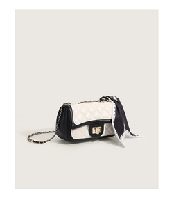 Détail du sac à bandoulière matelassé noir et blanc avec chaîne dorée et foulard en soie