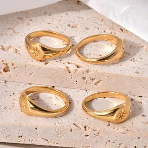 Set of four gold-plated stainless steel signet rings with embossed star patterns