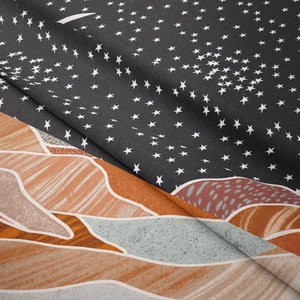 Détail macro d'une tapisserie bohème montrant des étoiles et des textures de montagnes