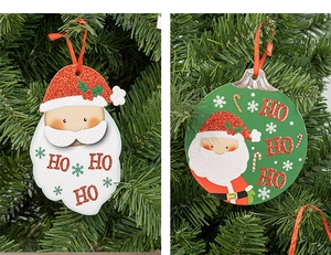 Close-up of glittery Santa Claus hanging ornament with HO HO HO text on a Christmas tree