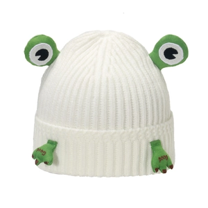 Detail of white knit hat featuring cute frog eyes and green paws with Good embroidery