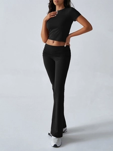 Detail of black short sleeve crop top and flared pants with folded waistband