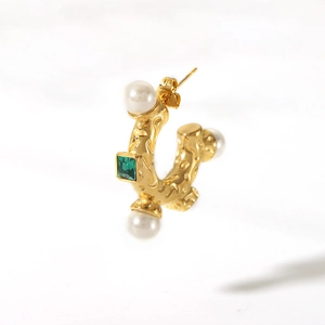 Detail of 18K gold-plated C-shaped earring with white pearls and green gemstone