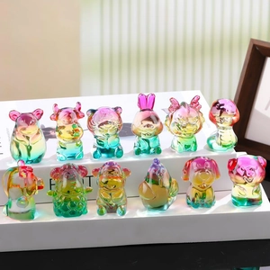 Set of 12 colorful crystal glass zodiac figurines with vibrant gradient colors on book