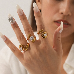 Close-up of three gold-plated adjustable rings with various zircon cuts on a model hand