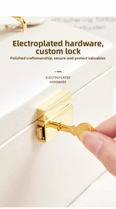 Close-up of elegant gold plated lock and key on ivory textured jewelry box surface