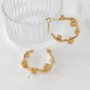Boucles d'oreilles C dorées polies avec boules métalliques géométriques et design moderne