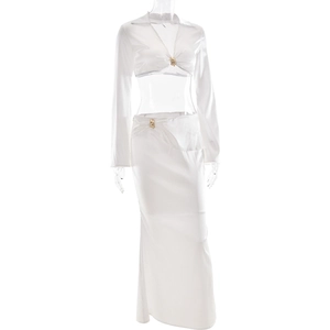 Détail d'un ensemble satiné blanc deux pièces avec boucle en métal doré et manches longues
