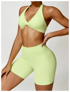 Détail de la brassière de sport vert néon à col croisé et du short de cyclisme taille haute