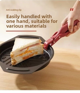 Detail of red anti-scalding clip lifting a baking pan with firm non-slip handle grip