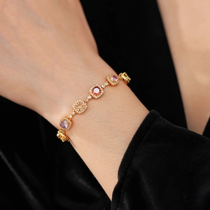 Macro detail of multi-colored square gemstones and halo diamonds on gold vintage bracelet