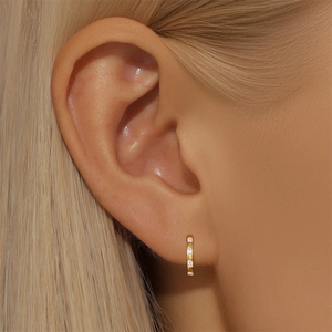 Macro shot of S925 silver gold-plated hoop earrings with rectangular white zircons