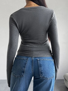 Vue détaillée du dos d'un t-shirt gris ajusté à manches longues montrant la coupe slim