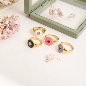 Detailed view of colorful heart enamel rings with gold plating and zircon inlay